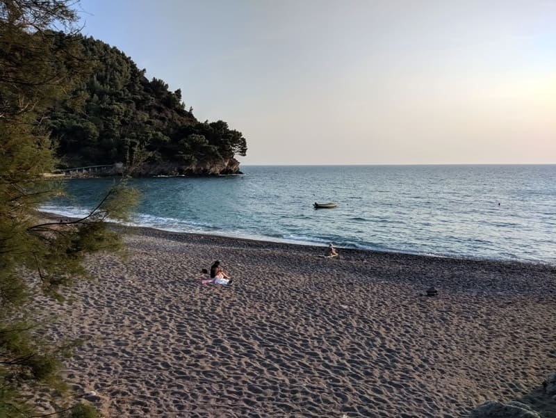 Небольшая морская бухта с пляжем, лодкой и лесистым мысом